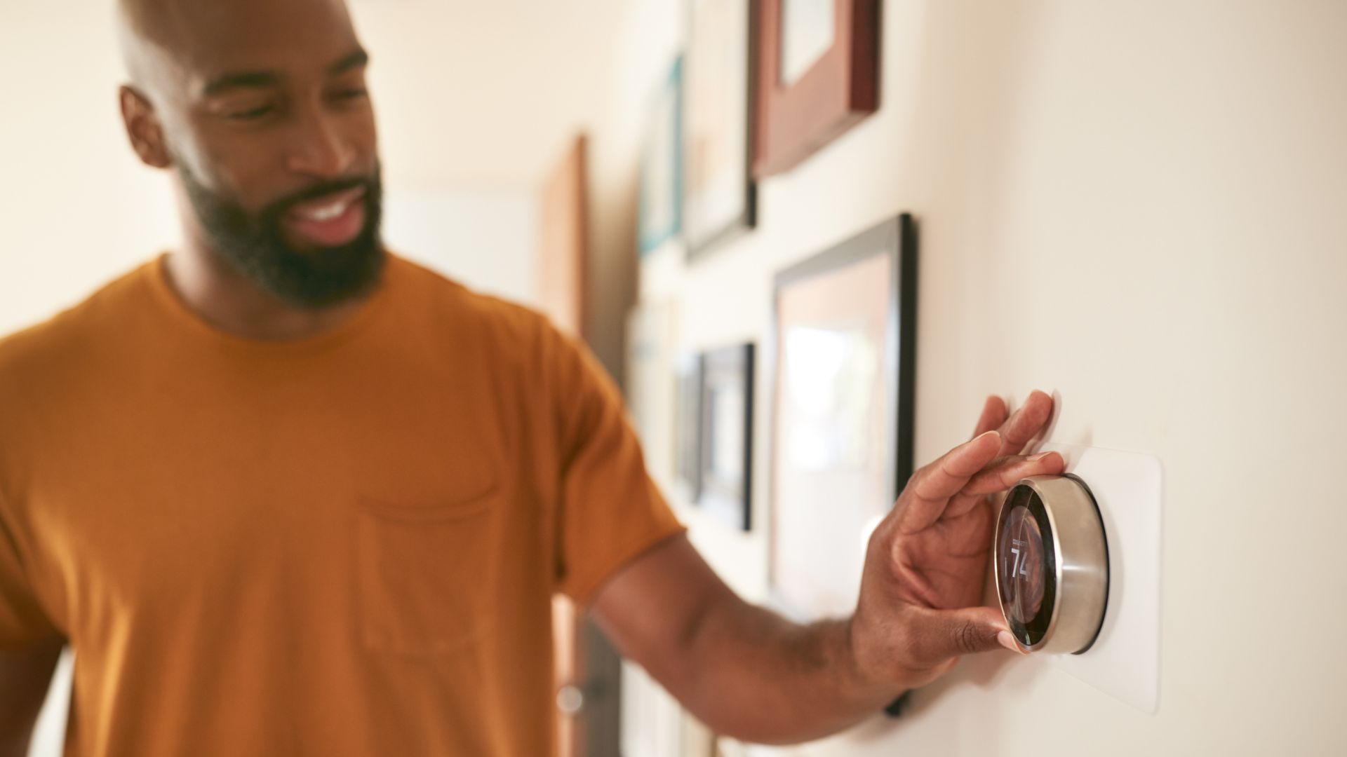 Homeowner adjusting a smart thermostat in Ann Arbor to prepare for winter furnace maintenance.